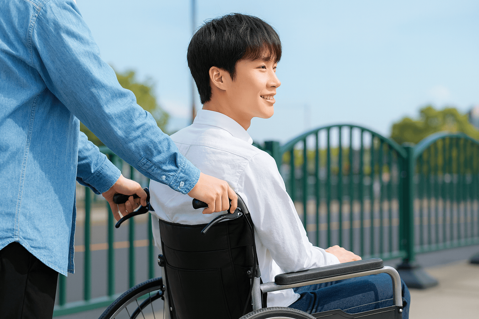 車いすを押してもらう男性